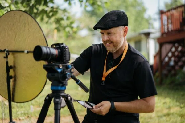 Professional videographer setting up a camera for corporate video services, creating high-quality brand video production outdoors.