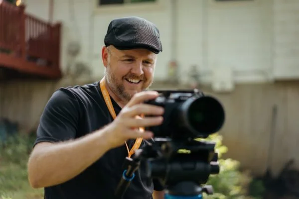 Professional videographer setting up a cinema camera for event video production, capturing high-quality corporate video footage.