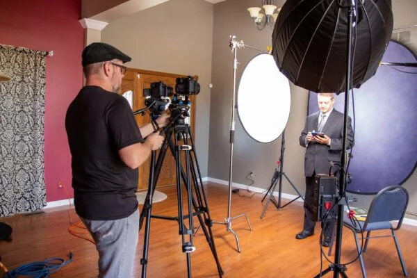 Professional franchise marketing video production with videographer filming a corporate spokesperson in a studio setup.